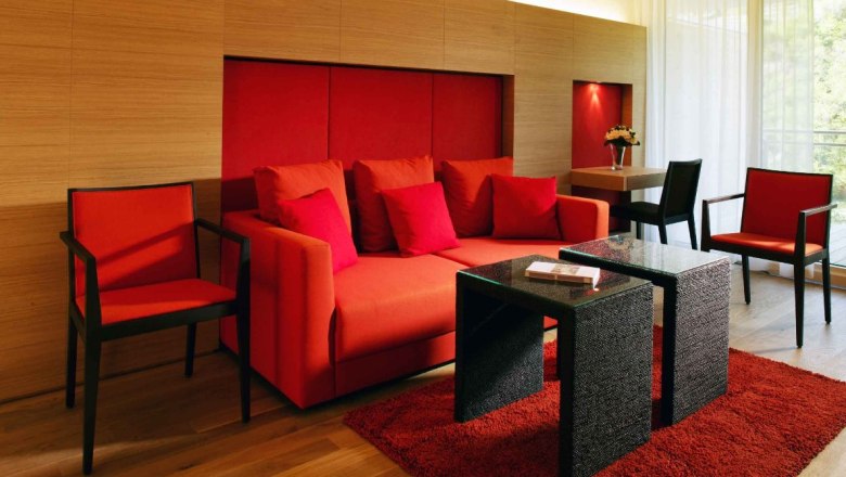Modern suite with red furniture and wooden walls.