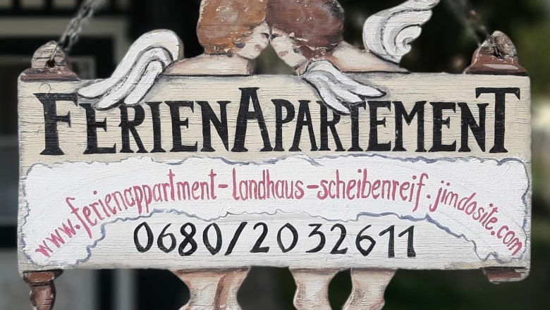 Wooden sign with the inscription 'Ferienapartement' and two angels.