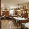 Cozy dining room with wooden furniture, green curtains and hunting trophies on the wall.