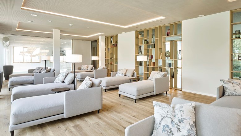 Modern lounge area in the spa with gray sofas and shelves at the Steigenberger Krems.