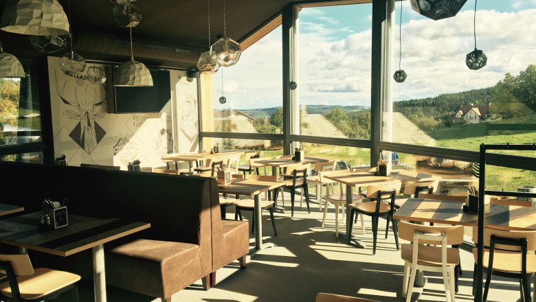 Interior view of the Wexl Lounge with large windows and a view of the countryside.