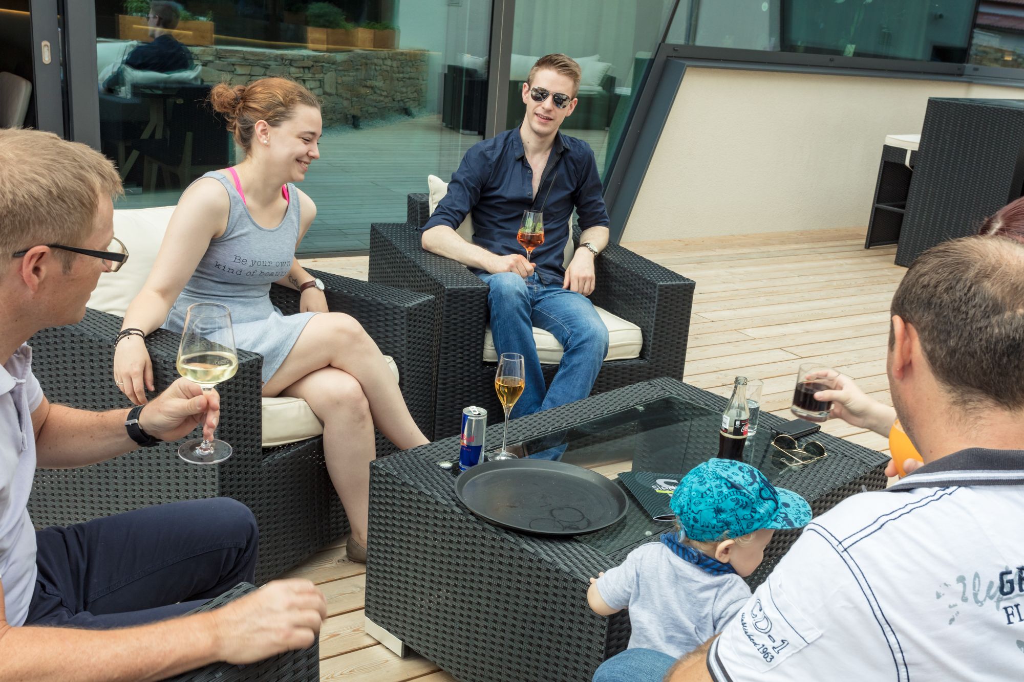 Group of people sitting on a terrace drinking drinks.