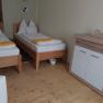 Twin room with two single beds, wooden floor and chest of drawers.