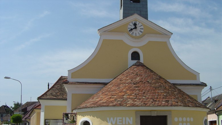 Yellow church with clock tower and 'Weinkirche' lettering in Jetzelsdorf.
