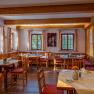 Cozy dining room with wooden furniture and laid tables.