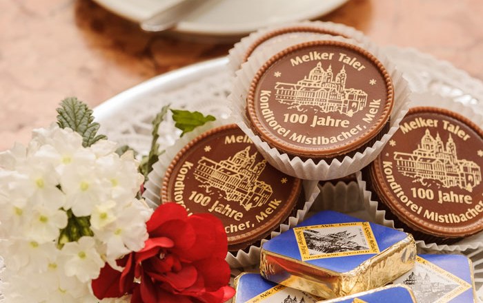A plate of chocolates and chocolate, with a cup of coffee next to it.