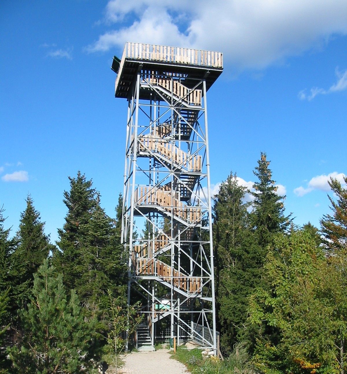 Observation tower in the forest with blue sky.