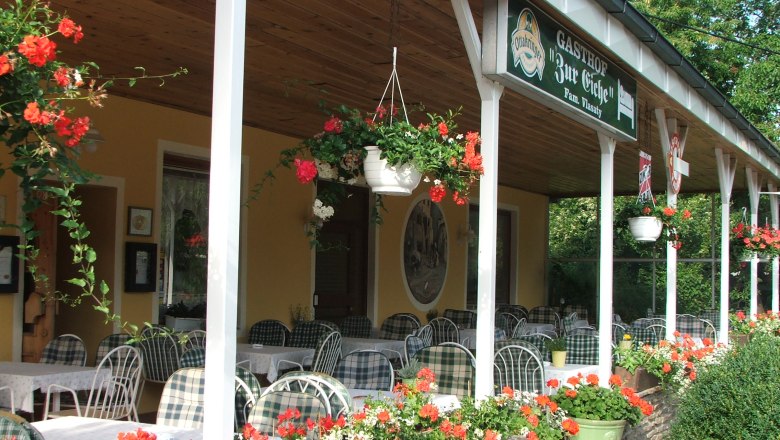 Outdoor area of an inn with tables and flowers.