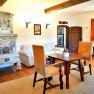 Cozy room with antique tiled stove, wooden furniture and carpet.