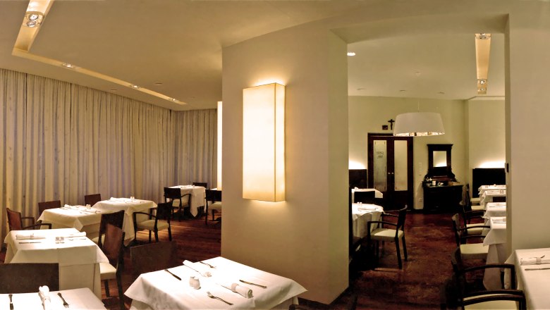 Elegant restaurant with set tables and subdued lighting.