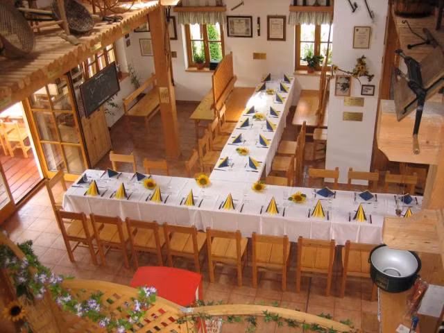 Interior view of an inn with set tables and wooden chairs.
