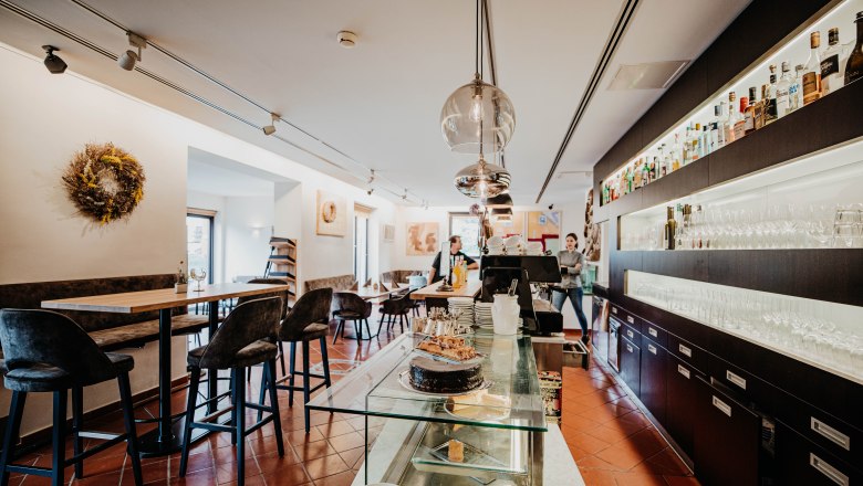 Interior view of a modern restaurant with bar, tables and chairs.