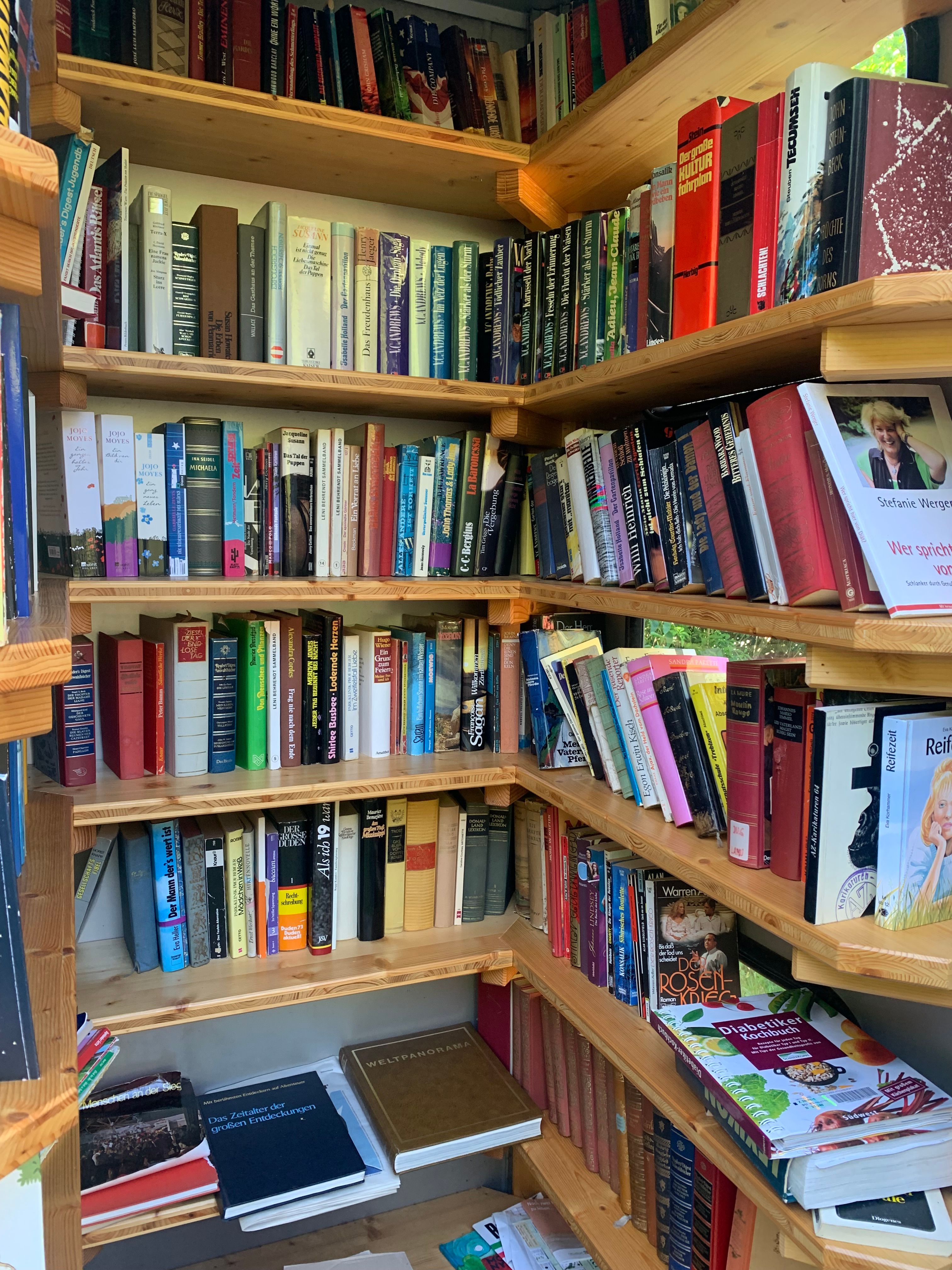 A bookshelf with various books in a public bookcase.
