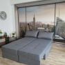 Room with gray sofa and photo wallpaper of New York skyline.