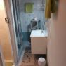 Small bathroom with shower, washbasin and towels.