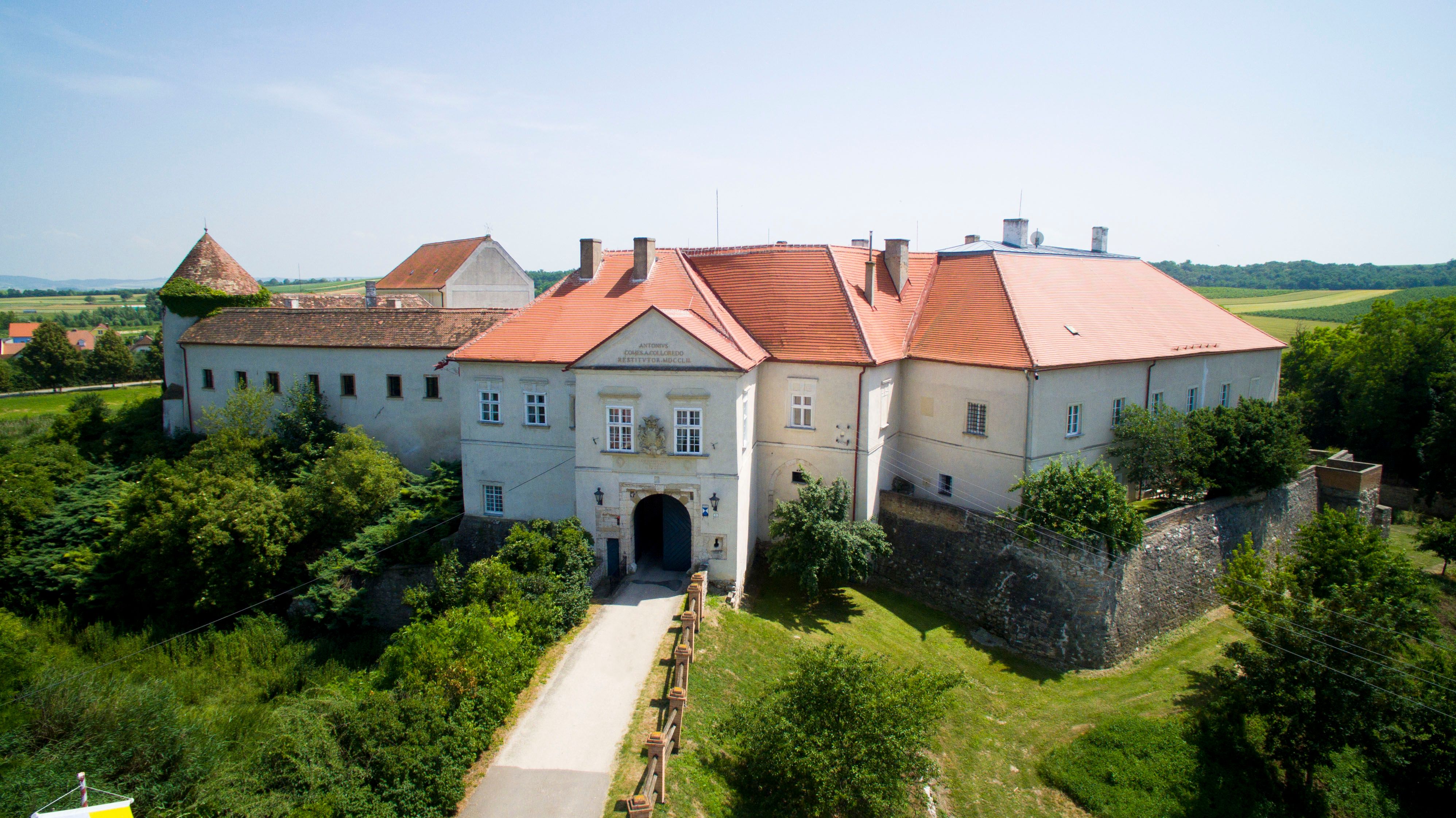 Aerial view of Mailberg Castle with red roofs and surrounding landscape.