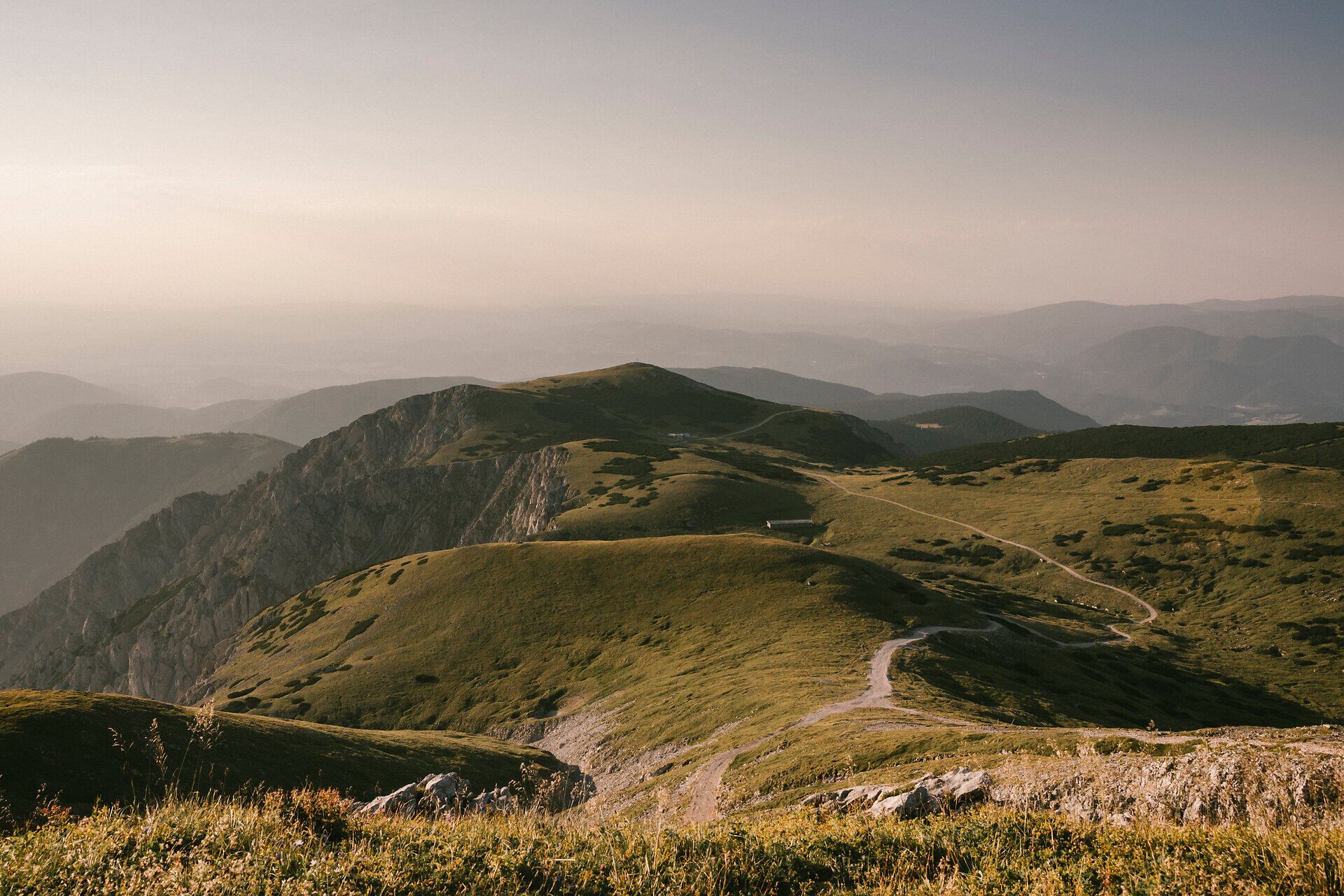 An evening view of the mountain landscape at Schneeberg, with gentle ridges and a sweeping view down into the valley