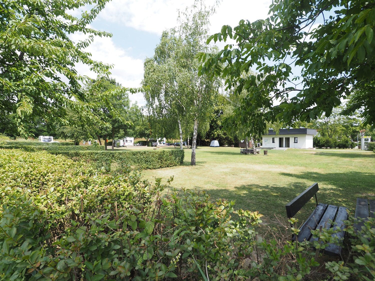 Pitch on a freshly mown meadow. In the background a small house for sanitary facilities.