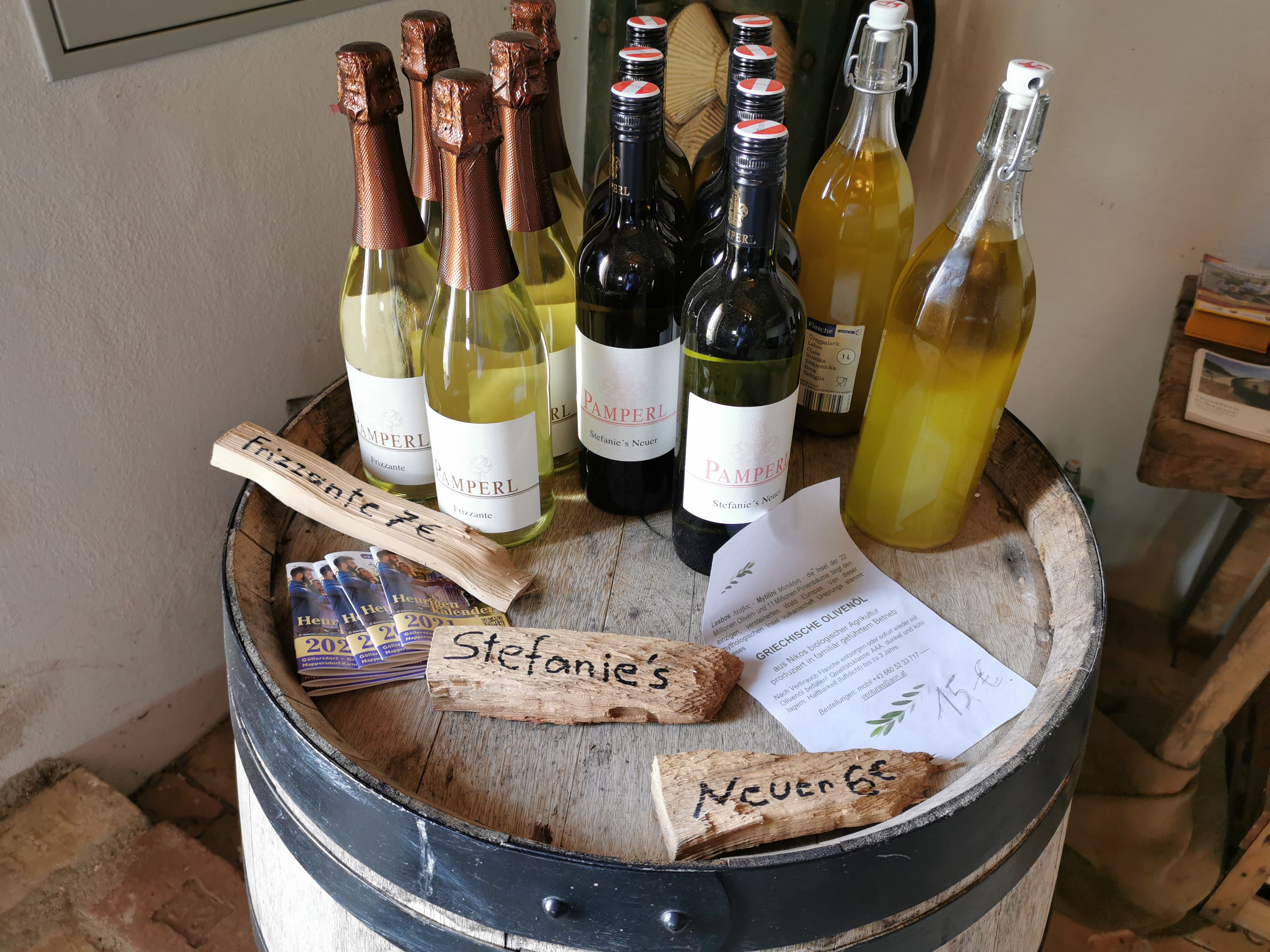 Wine bottles and flyers on a barrel.