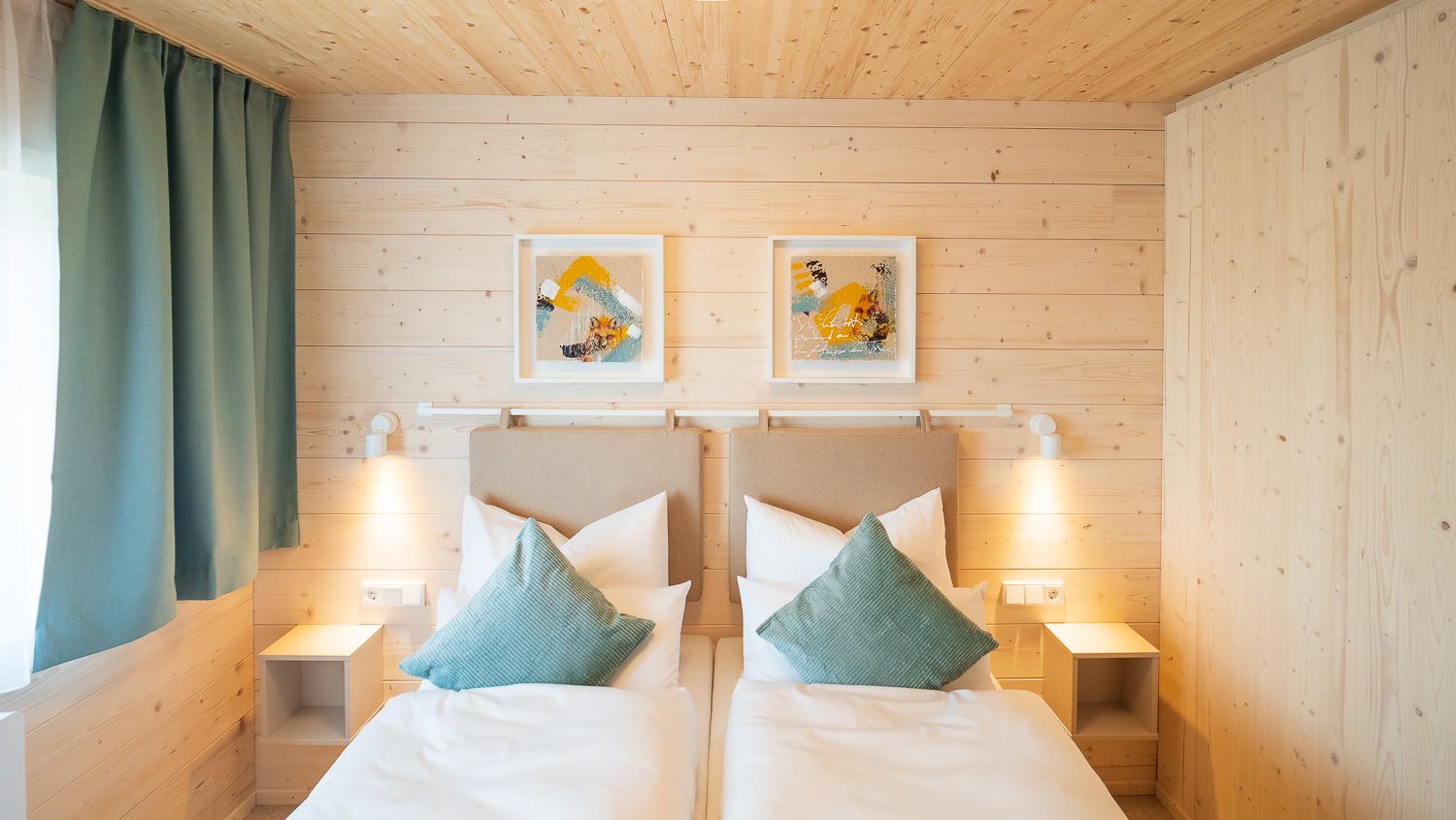 Cozy bedroom with two single beds, wooden walls and modern decoration.
