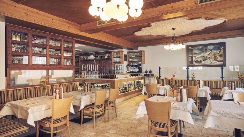 Interior view of a cozy restaurant with wooden furniture and decorative lights.