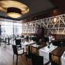 Elegant restaurant with modern Asian design elements, laid tables and large windows.