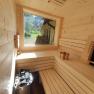 Interior view of a modern sauna with wood paneling and large window.