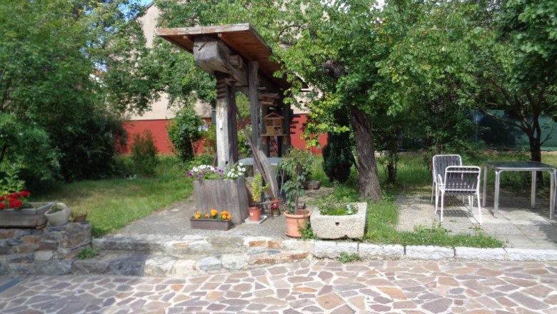 Apricot Garden House Gerlinde, © E.Dietz Garden with stone floor, plants and garden furniture.