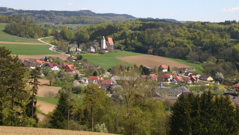 Landscape with village, church and hills in the background.