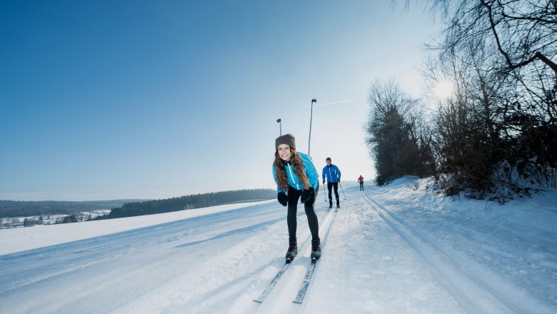 People cross-country skiing on a snow-covered trail in the Waldviertel.