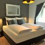 Modern bedroom with double bed, gray walls and decorative mirror.