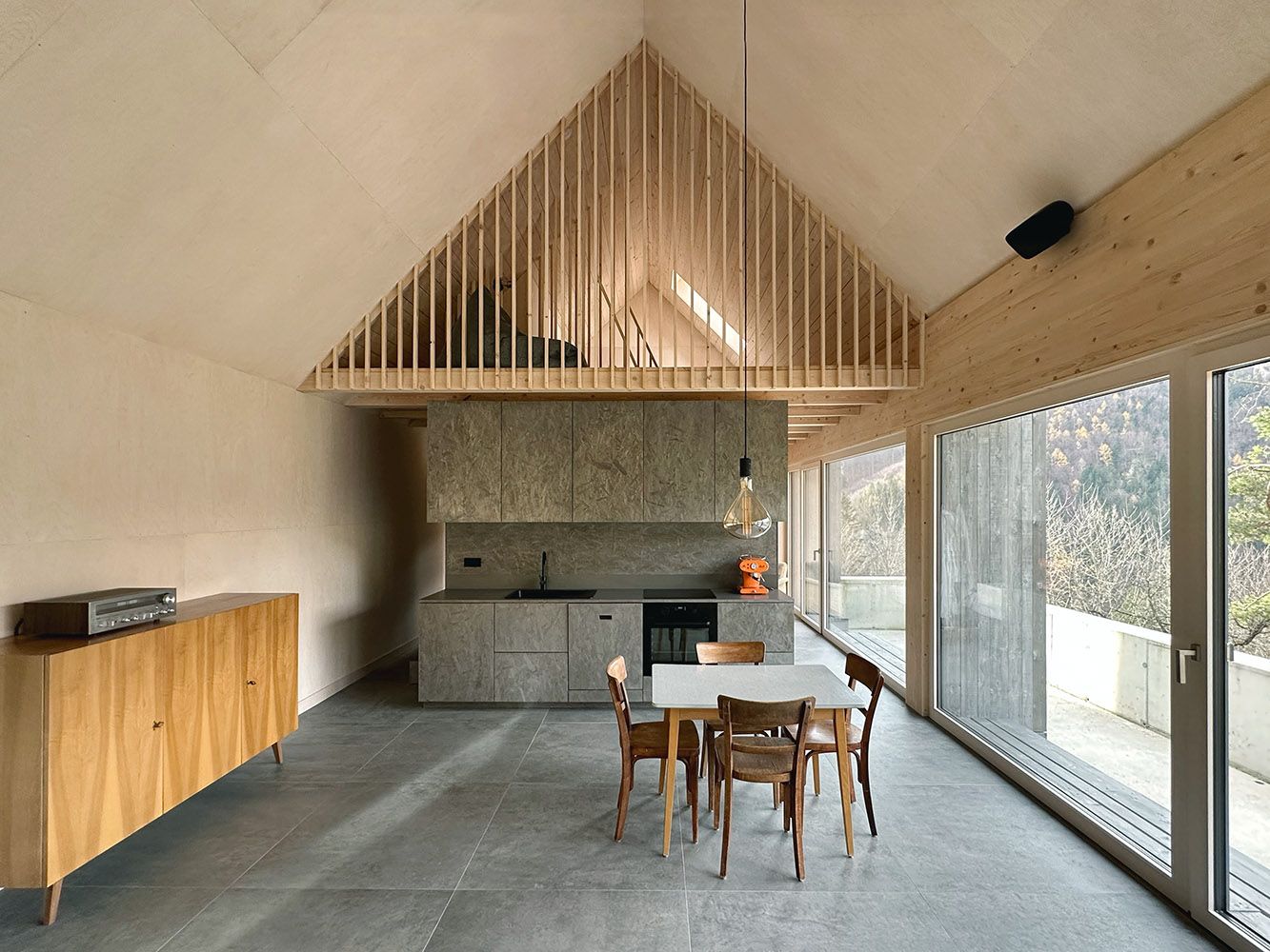 Modern open kitchen with wooden elements and large windows.