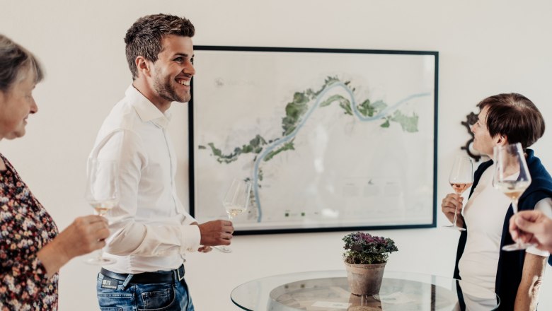 Group of people at a wine tasting in front of a map.