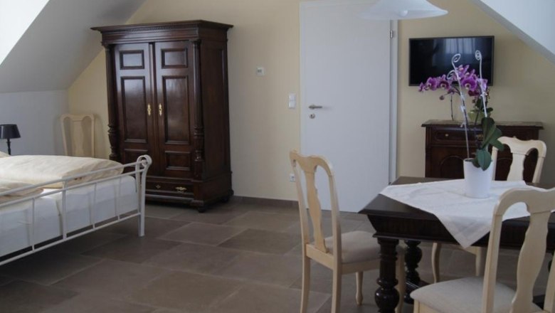 Room view_2, © Familie Osterhaus Bright room with bed, wardrobe, table and chairs.