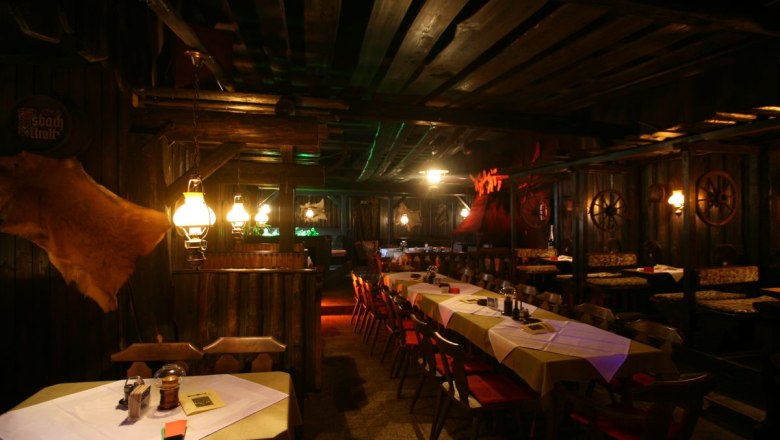 Rustic restaurant with wooden furniture and subdued lighting.