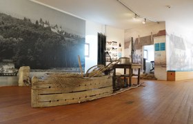 Interior view of a museum with historical fishing gear and murals.