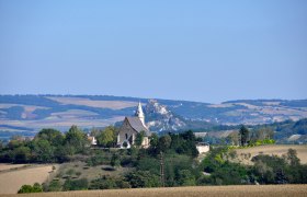 Landscape with church and hill in the background.