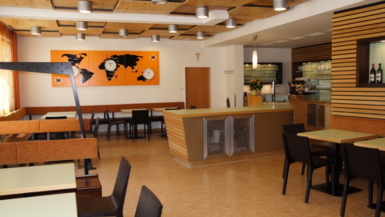 Interior view of a modern restaurant with wooden elements and world map decor.