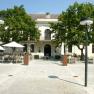 Exterior view of the tavern in Grafenegg Castle with tables and parasols on the forecourt.