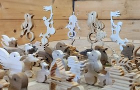 Wooden figures in animal and human form on a wooden table.