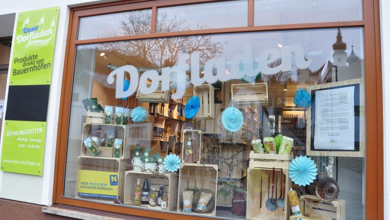 Shop window of a village store with products and decorations.