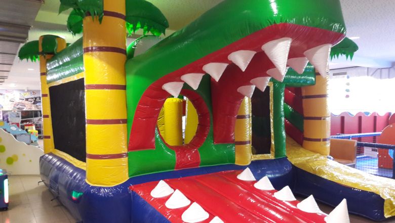 Inflatable bouncy castle in the shape of a crocodile with big teeth.