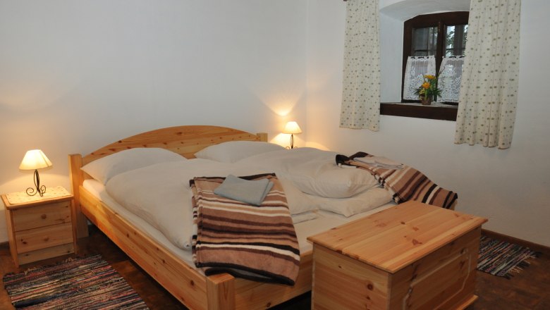 Vacation cottage Haltberghof, © Claudia Alber Cozy bedroom with wooden furniture and double bed.