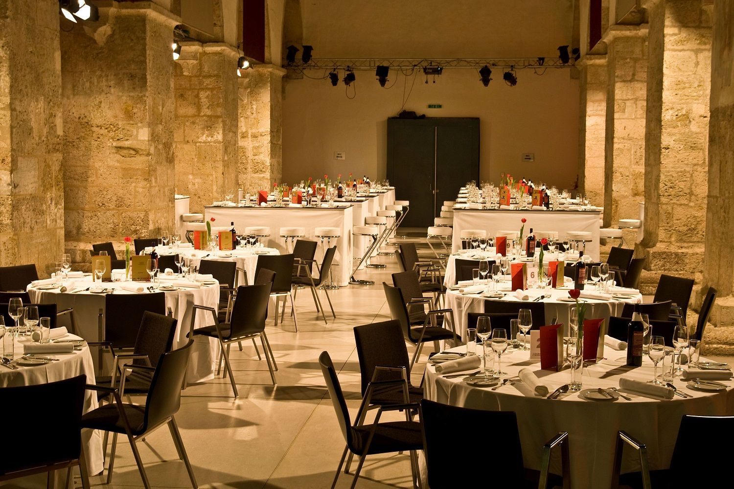 Elegant banquet hall in a historic church with set tables and chairs.