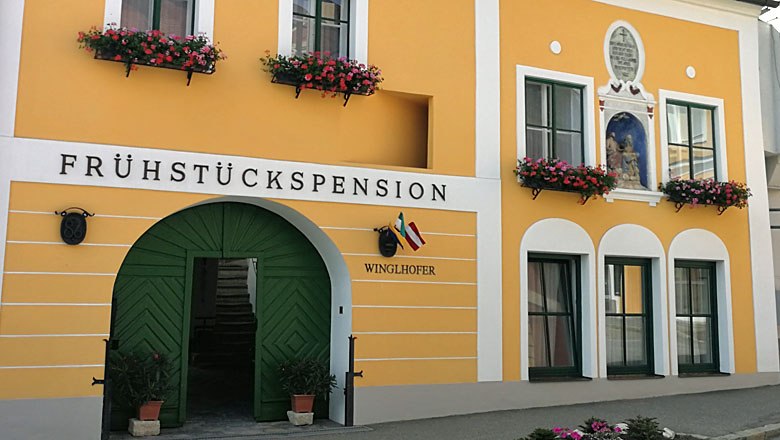 Guesthouse Winglhofer in Gars am Kamp, © Roman Zöchlinger Yellow guest house with green door and flower boxes.
