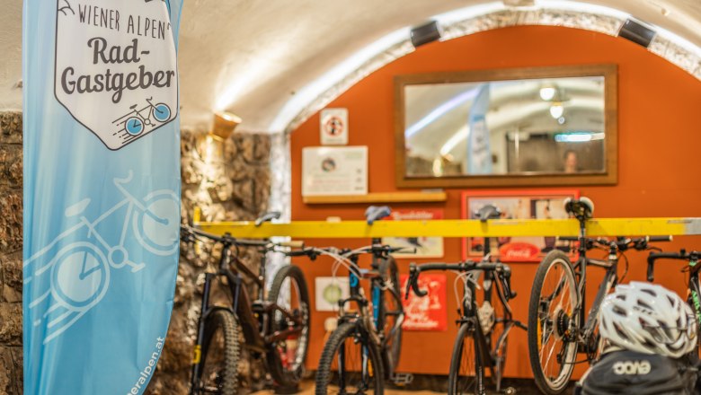 Bicycle garage with bicycles and a banner of the Vienna Alps bike hosts.