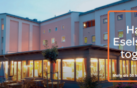 Exterior view of the JUFA Hotel at dusk with HolidayCheck Award 2016 logo.