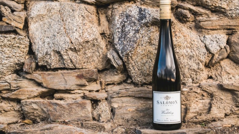 Wine bottle in front of a stone wall.