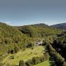 Aerial view of the Krainerhütte amidst wooded hills.