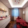 A stylishly furnished spa room with massage table, red towels and decorative elements.